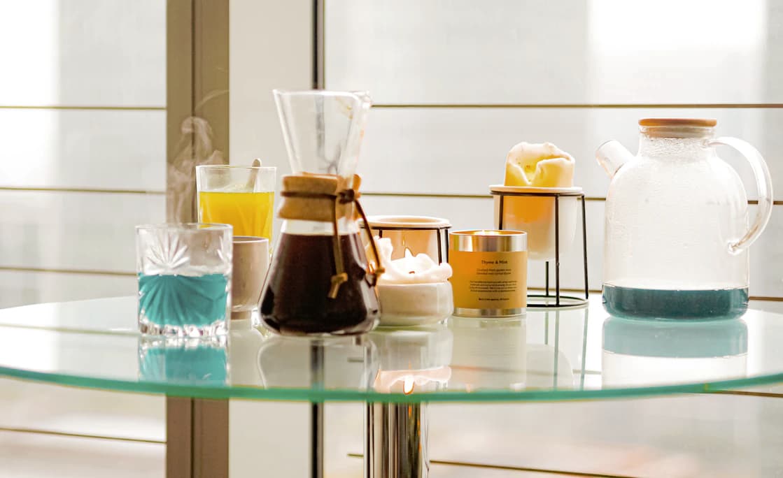 glass table with candles and various drinks on it