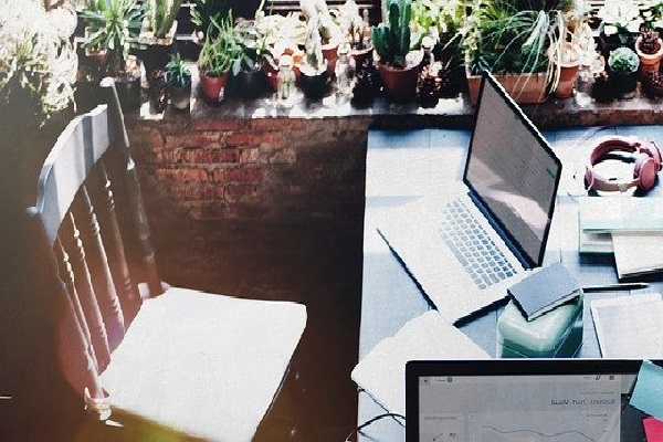 Un bureau avec un ordinateur, sous le soleil d'un bel après-midi.